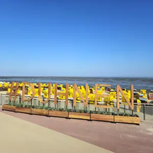 Holzschriftzug #DUHNEN am Strand von Cuxhaven mit gelben Strandkörben.