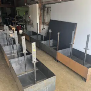 Metall-Pflanzkübel mit Haltepfosten in einer Werkstatt.